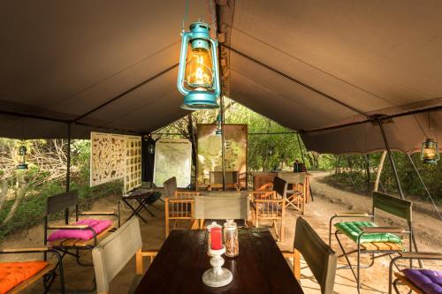 einen Essbereich im Freien mit einem Tisch und Stühlen in der Unterkunft Big Game - Udawalawe by Eco Team in Udawalawe
