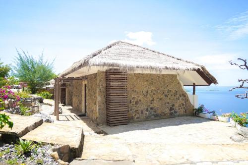 a small stone building with a thatch roof at Theodor at Labuan Bajo in Labuan Bajo