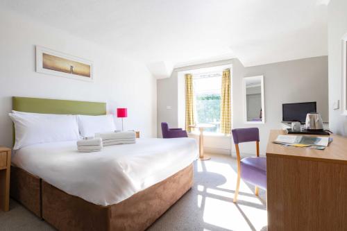 a bedroom with a bed and a desk and a computer at The Derwentwater Hotel in Keswick