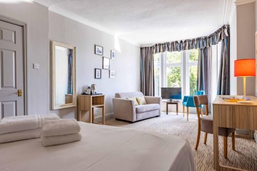 a bedroom with a bed and a desk and a chair at The Derwentwater Hotel in Keswick