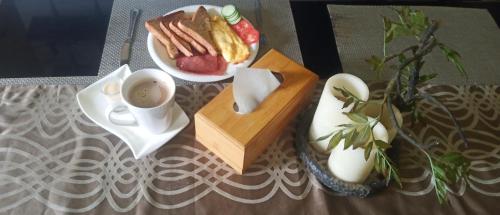 uma mesa com um prato de comida e uma xícara de café em Pinoykano home em Candijay