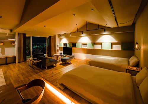 Habitación de hotel con cama y sala de estar. en D-and Stay 5 Resort Okinawa, en Urazoe