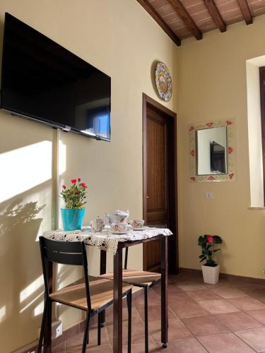 西恩納的住宿－La Casina Verde，一张桌子、椅子和墙上的电视