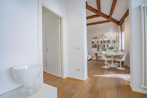 biały pokój ze stołem i szklanym wazonem w obiekcie Colleoni Apartment with 2 Superb Terraces w Wenecji