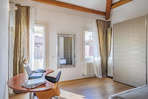 a room with a table with a laptop on it at Colleoni Apartment with 2 Superb Terraces in Venice