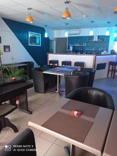 un restaurant avec des tables, des chaises et un comptoir dans l'établissement L'Estuaire, à Saint-Seurin-de-Cursac