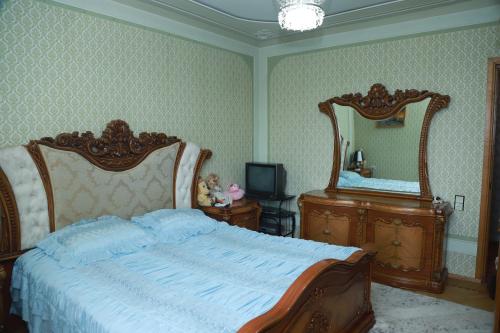 a bedroom with a large bed and two mirrors at Norik's Guest House in Sevan