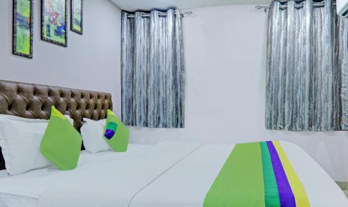 a bedroom with a bed with colorful pillows at Treebo Raj Inn Lalpur in Rānchī
