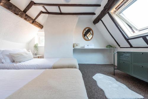 a bedroom with two beds and a mirror at Riverside Rest in Ollerton