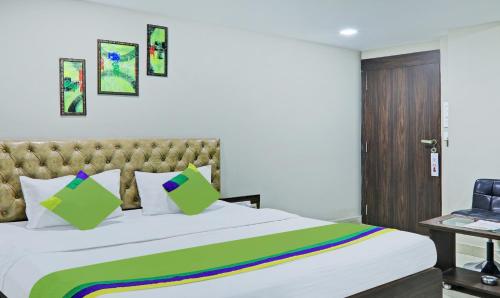 a bedroom with a bed with a green and yellow blanket at Treebo Raj Inn Lalpur in Rānchī