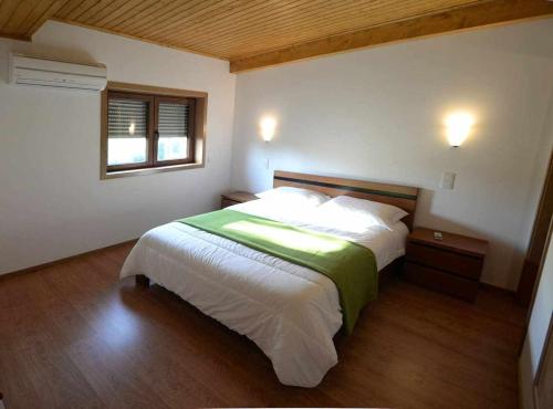 - une chambre avec un grand lit dans l'établissement Casa do Tanque Camélias de Basto, à Castelbuono