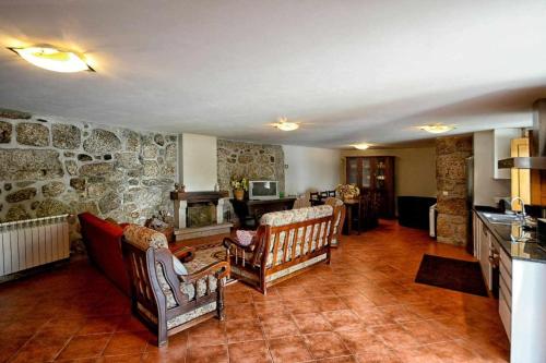 a living room with chairs and a stone wall at Casa de Barreiros (Camélias de Basto) in Lamelas