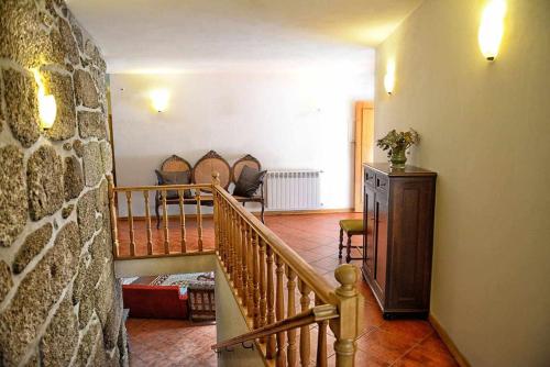 LamelasCasa de Barreiros Camélias de Basto的一间设有楼梯和石墙的房间
