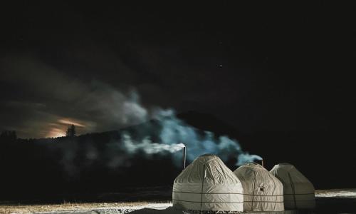 a group of domes with smoke coming out of them at Karkyra Yurt Glamping in Sarytëbë
