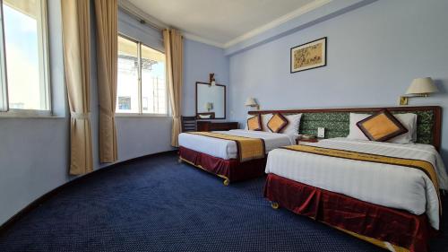 Postel nebo postele na pokoji v ubytování Thien Hong - Arc En Ciel Hotel