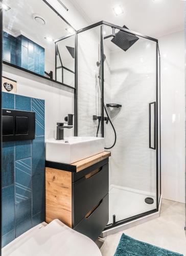 a bathroom with a shower and a sink at Hexagon Studio in Wrocław