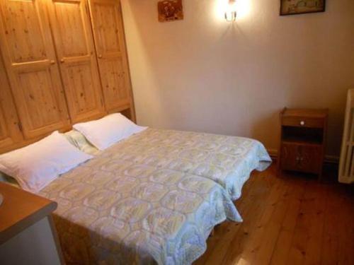 1 dormitorio pequeño con 1 cama y suelo de madera en La Tour en Combloux