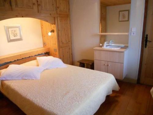 um quarto com uma cama e um lavatório em La Tour em Combloux