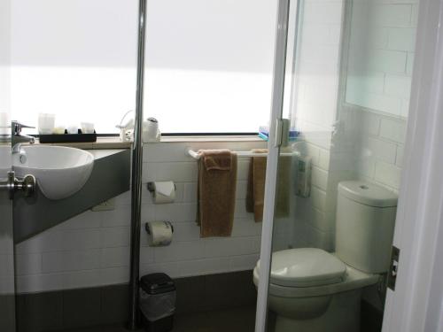 małą łazienkę z toaletą i umywalką w obiekcie Dalby Manor Motor Inn w mieście Dalby