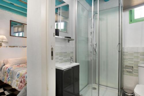 La salle de bains est pourvue d'une douche, d'un lavabo et d'un lit. dans l'établissement Casa Lola, à Vejer de la Frontera