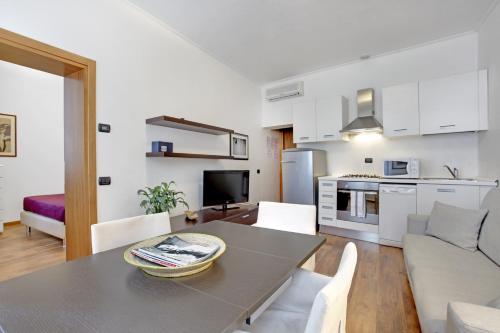 a kitchen and a living room with a table and chairs at Bricola Biennale Apartments in Venice