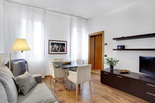 a living room with a table and a couch and a television at Bricola Biennale Apartments in Venice