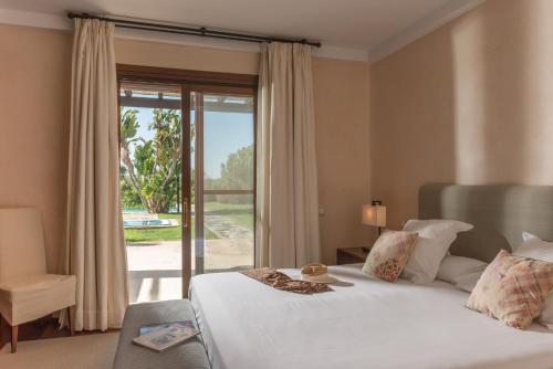 Schlafzimmer mit einem Bett und einer Glasschiebetür in der Unterkunft Villa Violeta in Benalup Casas Viejas