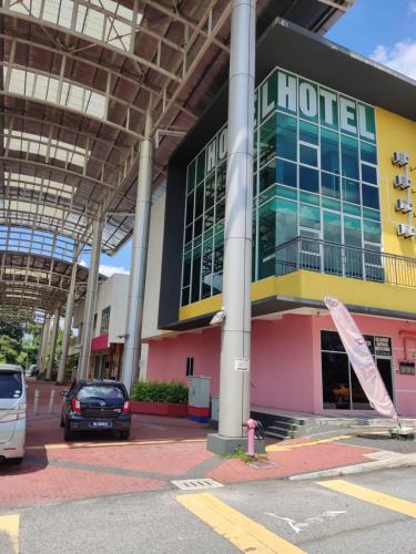 un hôtel avec une voiture garée devant lui dans l'établissement Hotel Oasis, à Batang Kali