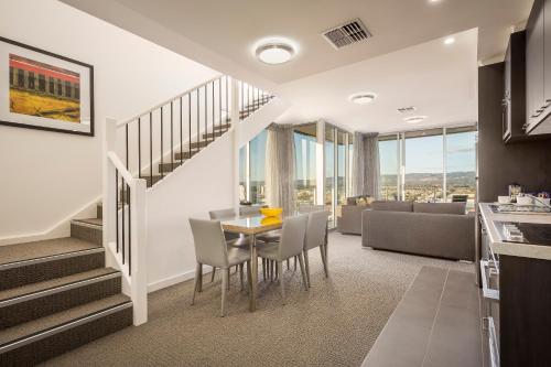 a dining room and living room with a table and chairs at Quest King William South in Adelaide