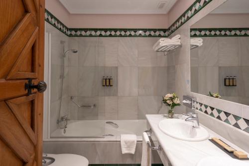 a bathroom with a tub and a sink and a shower at Parador de Guadalupe in Guadalupe