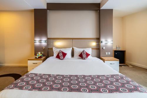 a hotel room with a large bed with red pillows at PrideInn Azure Hotel Nairobi Westlands in Nairobi