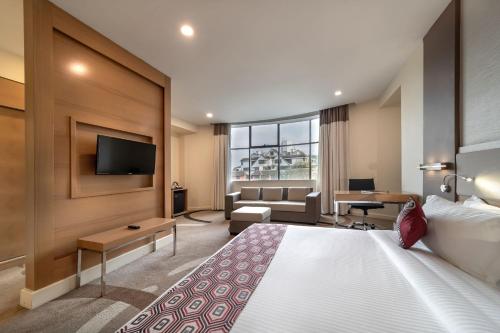 a hotel room with a bed and a flat screen tv at PrideInn Azure Hotel Nairobi Westlands in Nairobi