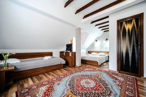 a bedroom with two beds and a rug at Pension Valeria in Voronet