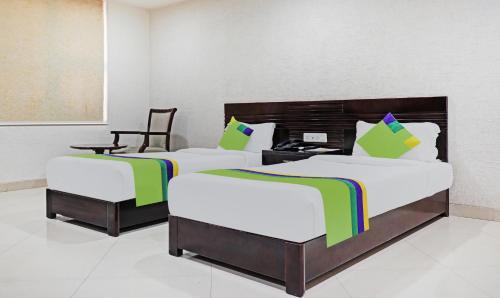 two beds in a hotel room with a desk at Treebo Trend Elite City Upper Bazar in Rānchī