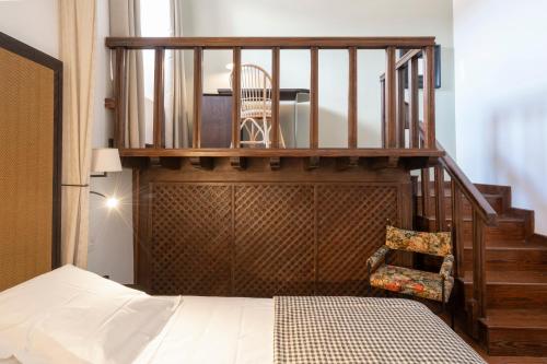 a bedroom with a staircase with a chair and a bed at Parador de Guadalupe in Guadalupe