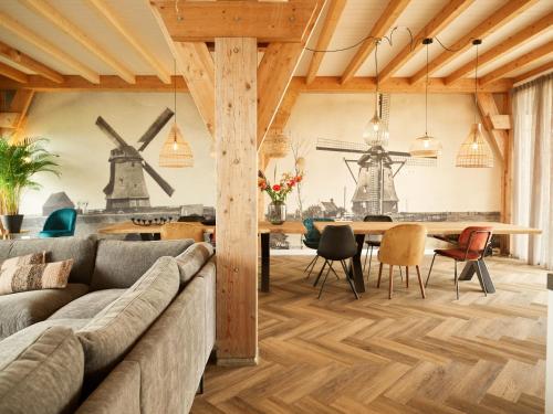 a living room with a couch and a table with chairs at Dutchen Erfgoedpark De Hoop Vakantiewoningen in Uitgeest