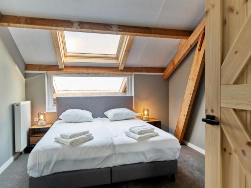 Un dormitorio con una cama grande y una ventana en Erfgoedpark De Hoop Vakantiewoningen, en Uitgeest