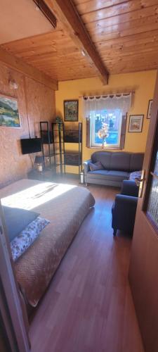 a bedroom with a large bed and a living room at Stanica pod Zadzierną Domki całoroczne in Lubawka