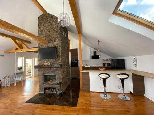 a kitchen and living room with a stone fireplace at Attic 33 in Câmpulung Moldovenesc