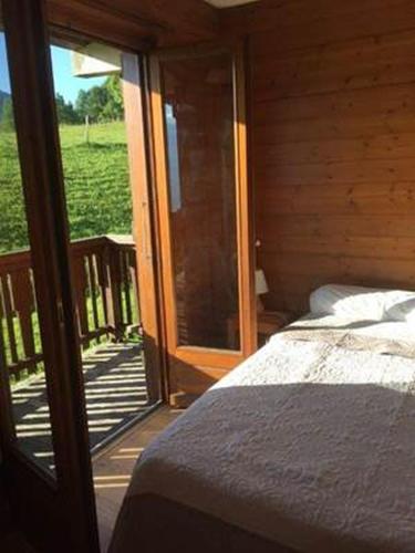 une chambre avec un lit et une porte coulissante en verre dans l'établissement Les Hauts de Plommaz, à Combloux