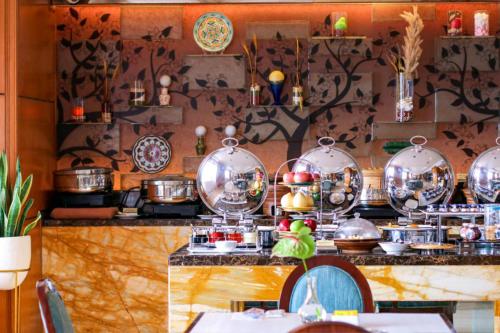 a kitchen with many pots and pans on a counter at Hotel Ciputra Jakarta managed by Swiss-Belhotel International in Jakarta