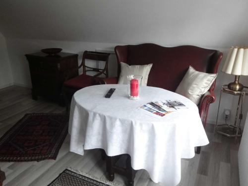 Ferienwohnung Hansen in Hafennähe في كابلن: طاولة بيضاء عليها شمعة