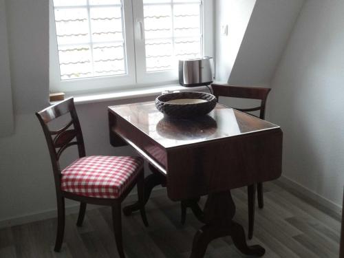 Ferienwohnung Hansen in Hafennähe في كابلن: طاولة غرفة طعام مع كرسيين ووعاء عليها