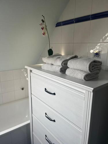 eine weiße Kommode mit Handtüchern darüber im Bad in der Unterkunft Khon Thai's House Brugge in Brügge
