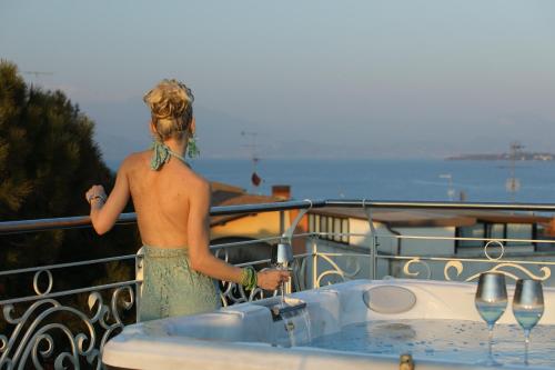 a man standing next to a bath tub on a boat at B&B Bellavista Exclusive in zona centrale con piscina riscaldata e Jacuzzi vista lago LA COLAZIONE viene servita in una pasticceria rinomata ed esclusiva esterna alla struttura in Desenzano del Garda