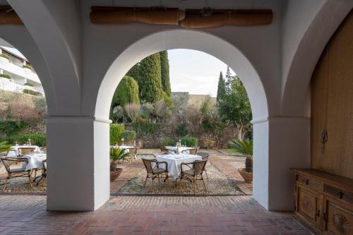 an archway with tables and chairs in a courtyard at Parador de Guadalupe in Guadalupe