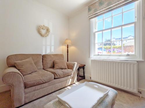 ein Wohnzimmer mit Couch und großem Fenster in der Unterkunft Seashell Cottage - Worthing in Worthing