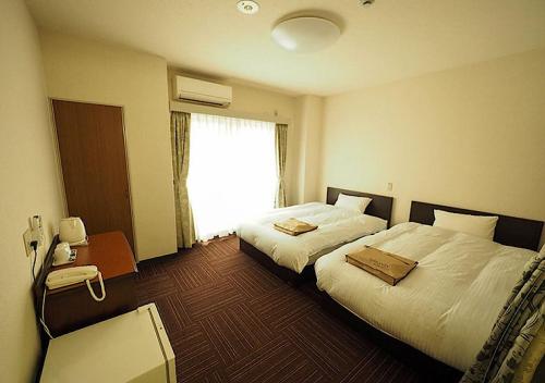 a hotel room with two beds and a window at Urbanty Nishikujo - Vacation STAY 08538v in Osaka