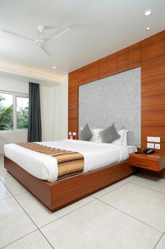 a bedroom with a large bed with a wooden headboard at Nexstay River Mouth International in Ferokh