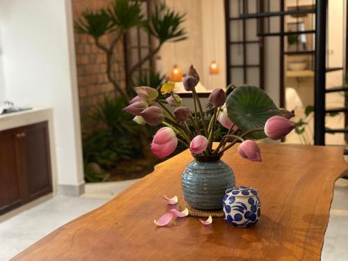 a vase with flowers in it sitting on a table at Okra Hoian in Hoi An